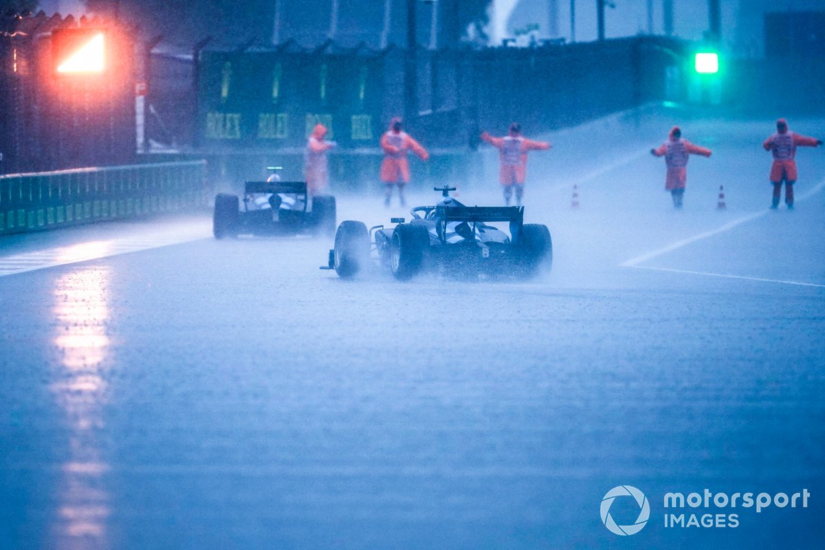 Rain lashes down in the pit lane as the red light is displayed at the exit