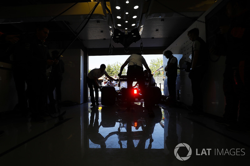 McLaren engineers return a car to the garage