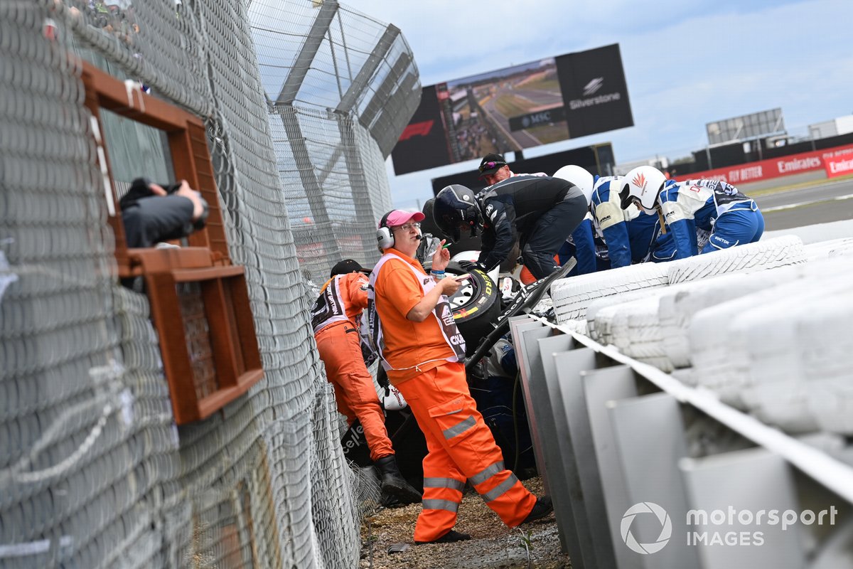I commissari e i medici assistono Guanyu Zhou per estrarlo dall'Alfa Romeo C42