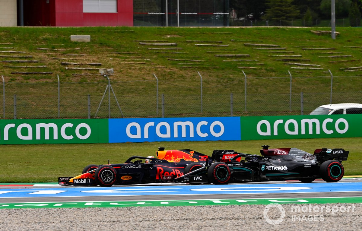 Max Verstappen, Red Bull Racing RB16B, melewati Sir Lewis Hamilton, Mercedes W12, untuk memimpin lomba GP Spanyol setelah start.