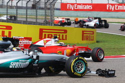 Kimi Raikkonen, Ferrari SF16-H, en Lewis Hamilton, Mercedes AMG F1 W07, met kapotte voorvleugels bij