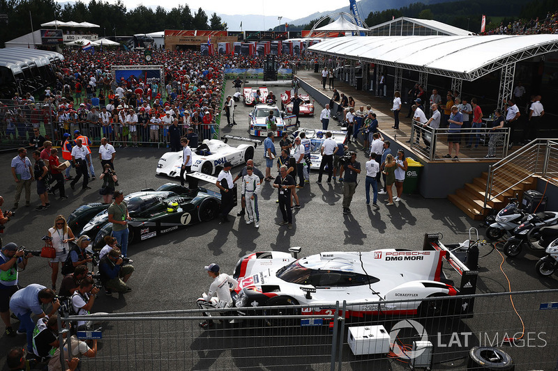 Brendon Hartley posa con un Porsche 919 sportcar. Un Bentley, BMW V12 LMR, Group C Porsche, BMW CSL, Ferrari 512 y Porsche 917 alineados