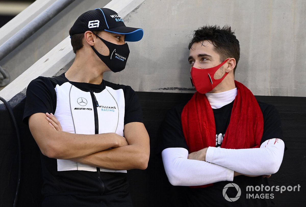 George Russell, Williams Racing, talks with Charles Leclerc, Ferrari, on the grid