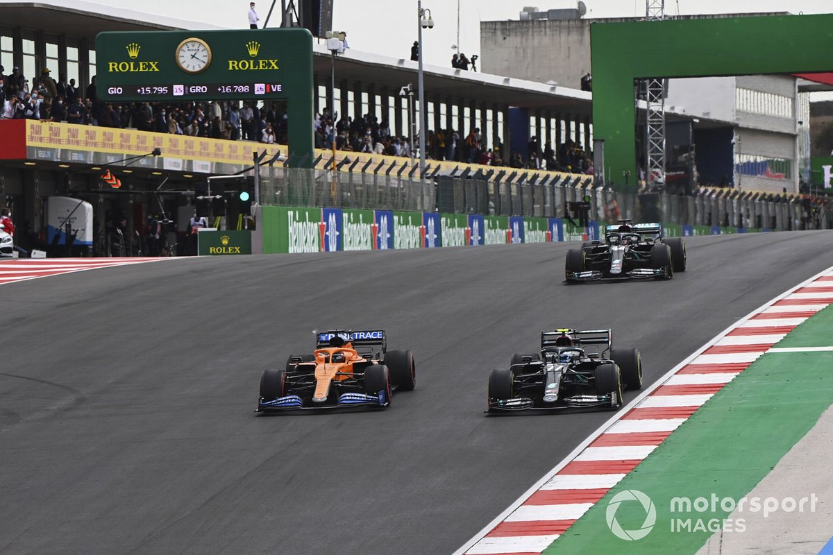 Carlos Sainz Jr (kiri) yang menggeber McLaren MCL35 menempel ketat pembalap Tim Mercedes-AMG Petronas, Valtteri Bottas. Rekan setim Bottas, Lewis Hamilton, terlihat berusaha mengejar. Duel ini terjadi di GP Portugal 2020 lalu.