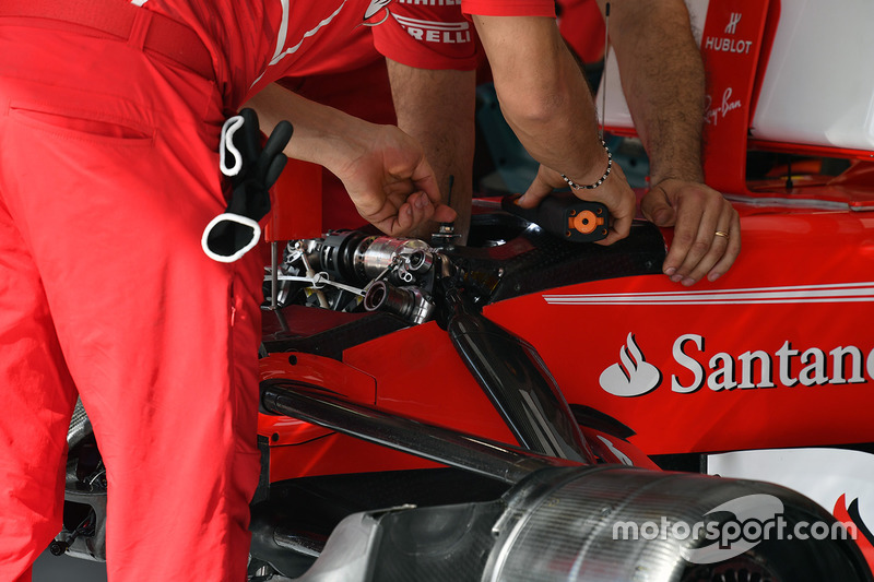 Los mecánicos de Ferrari realizando ajustes en la suspensión delantera del SF70H