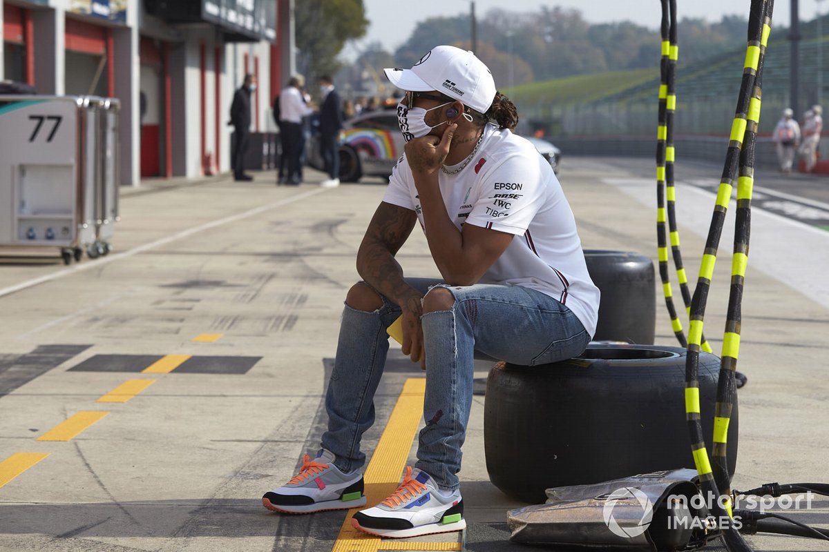 Lewis Hamilton, Mercedes-AMG F1, sits on a tyre in the pit lane