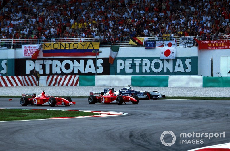 Rubens Barrichello, Ferrari F2001 takes the lead as Juan Pablo Montoya, Williams FW24 runs wide after being hit by Michael Schumacher, Ferrari F2001 at the first corner