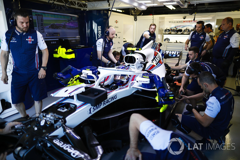 Mechanics work on the Lance Stroll Williams FW41 in the team's garage