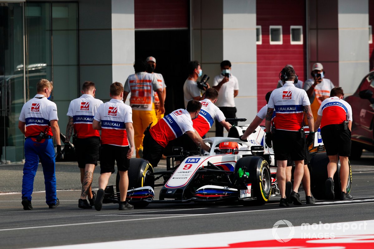 Mechanics push Nikita Mazepin, Haas F1, back along the pitlane after he stopped at the end of the pitlane