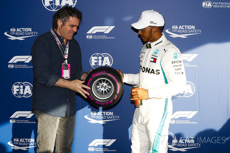 Lewis Hamilton, Mercedes AMG F1, signs a miniature Pirelli tyre after taking pole position