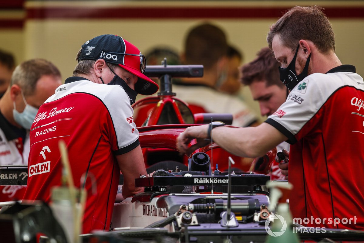 Di balik pembawaannya yang dingin, Kimi Raikkonen (kiri) ternyata selalu memperhatikan hal-hal detail. Tampak ia membantu seorang mekanik Tim Alfa Romeo memperbaiki mobil di paddock.