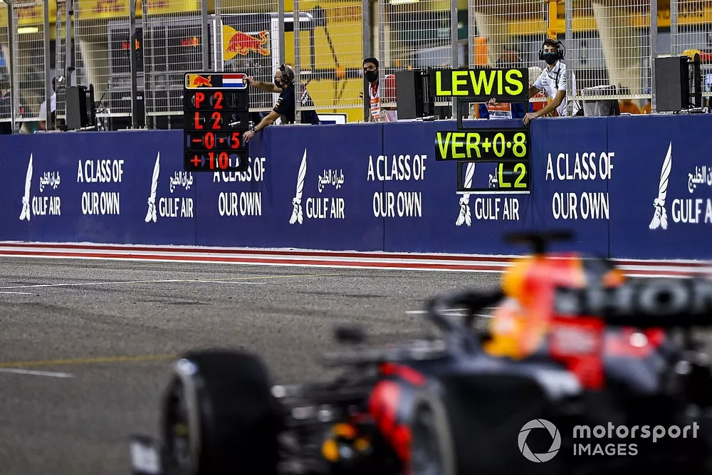 Max Verstappen, Red Bull Racing RB16B, passes the pit boards