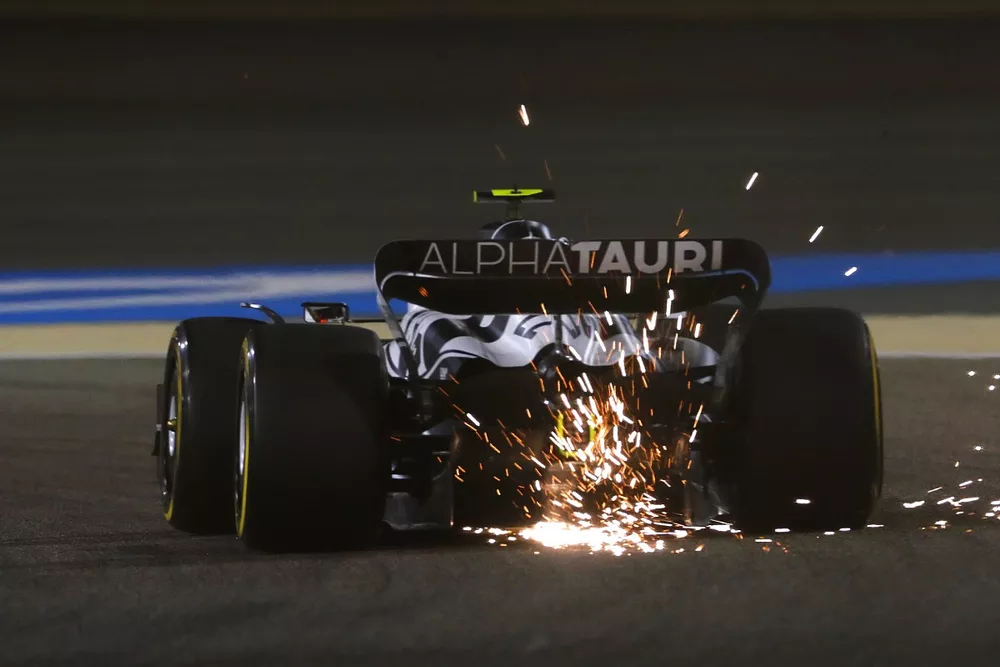 Sparks kick up from the rear of Yuki Tsunoda, AlphaTauri AT03