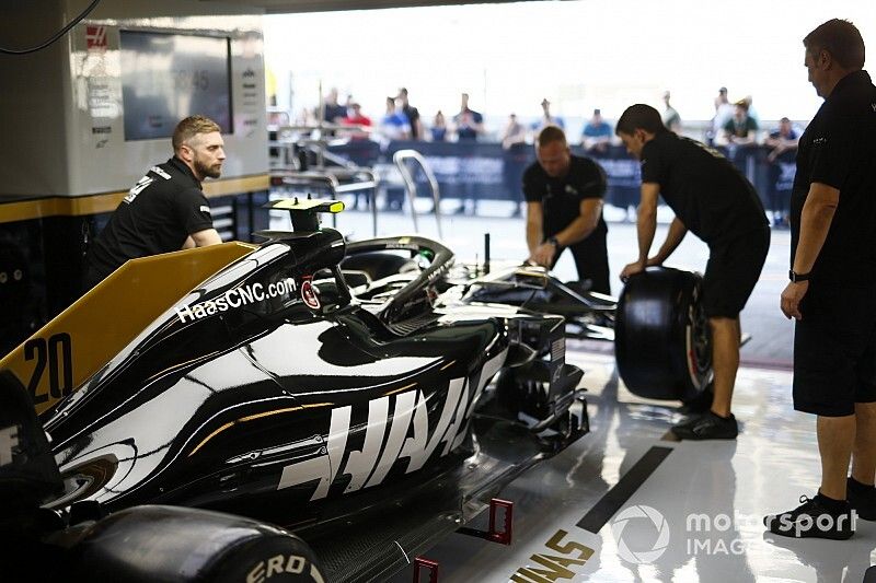 Mec&aacute;nicos trabajando en el coche de Kevin Magnussen, el Haas F1 Team VF-19, en el box
