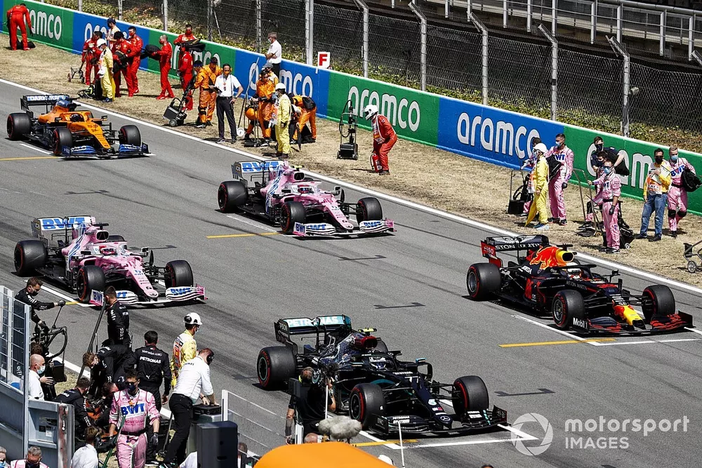 Los mec&aacute;nicos despejan la parrilla mientras Valtteri Bottas, Mercedes F1 W11 EQ Performance, Max Verstappen, Red Bull Racing RB16, Sergio P&eacute;rez, Racing Point RP20, Lance Stroll, Racing Point RP20, Carlos Sainz Jr., McLaren MCL35, se preparan para iniciar la vuelta de formaci&oacute;n