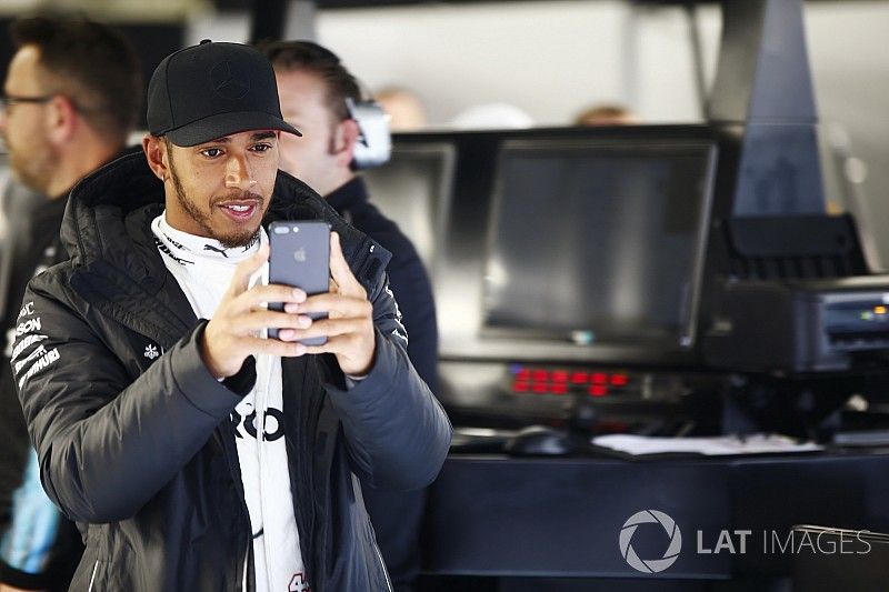 Lewis Hamilton, Mercedes AMG, avec son téléphone dans le garage