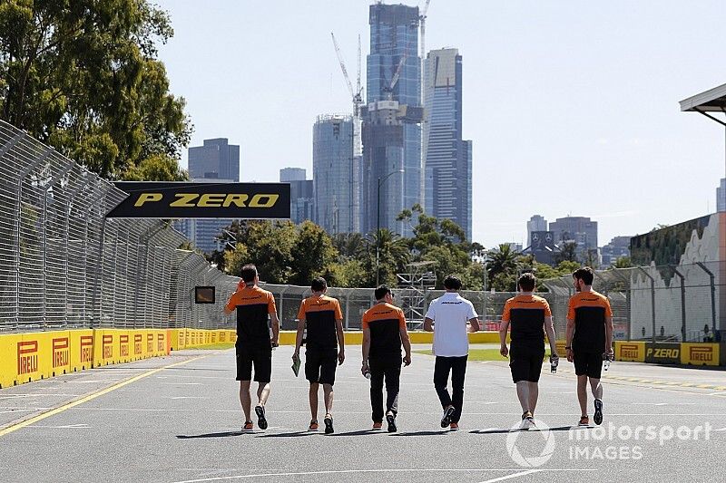 Members of the McLaren team walk the track