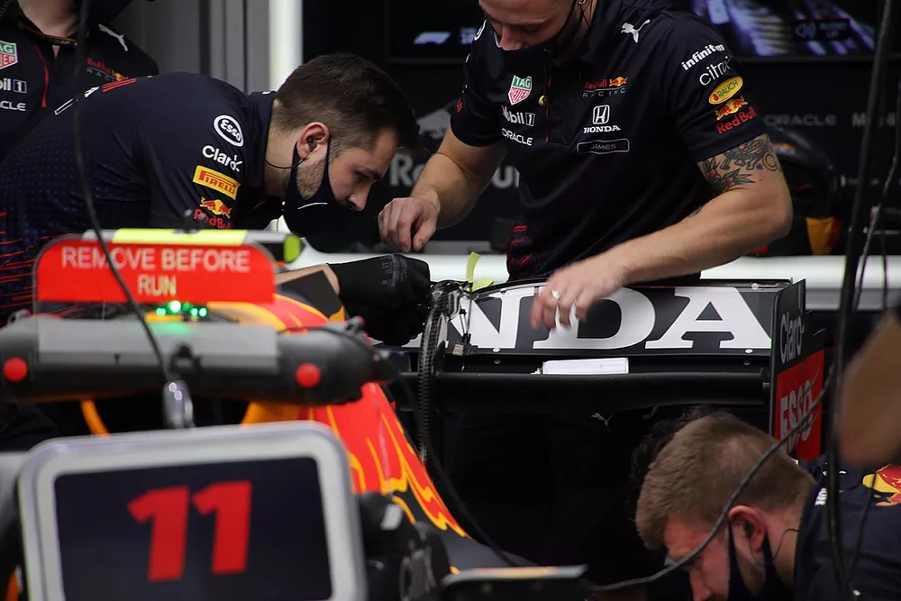 Miembros del equipo Red Bull Racing trabajando en el aler&oacute;n trasero