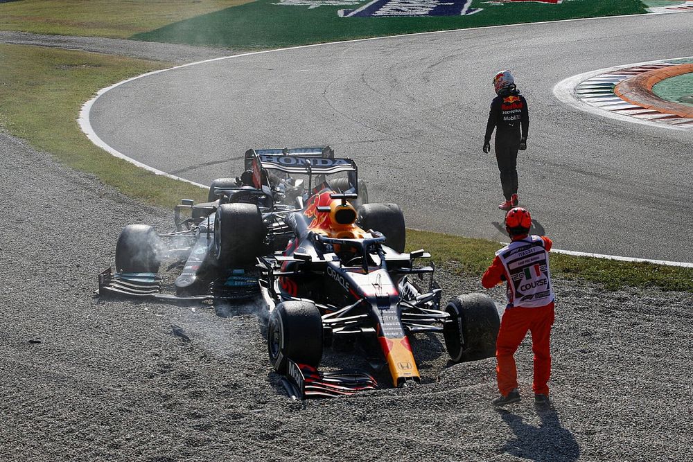 Max Verstappen, Red Bull Racing, se aleja mientras un oficial de pista asiste en el lugar de su accidente con Lewis Hamilton, Mercedes W12