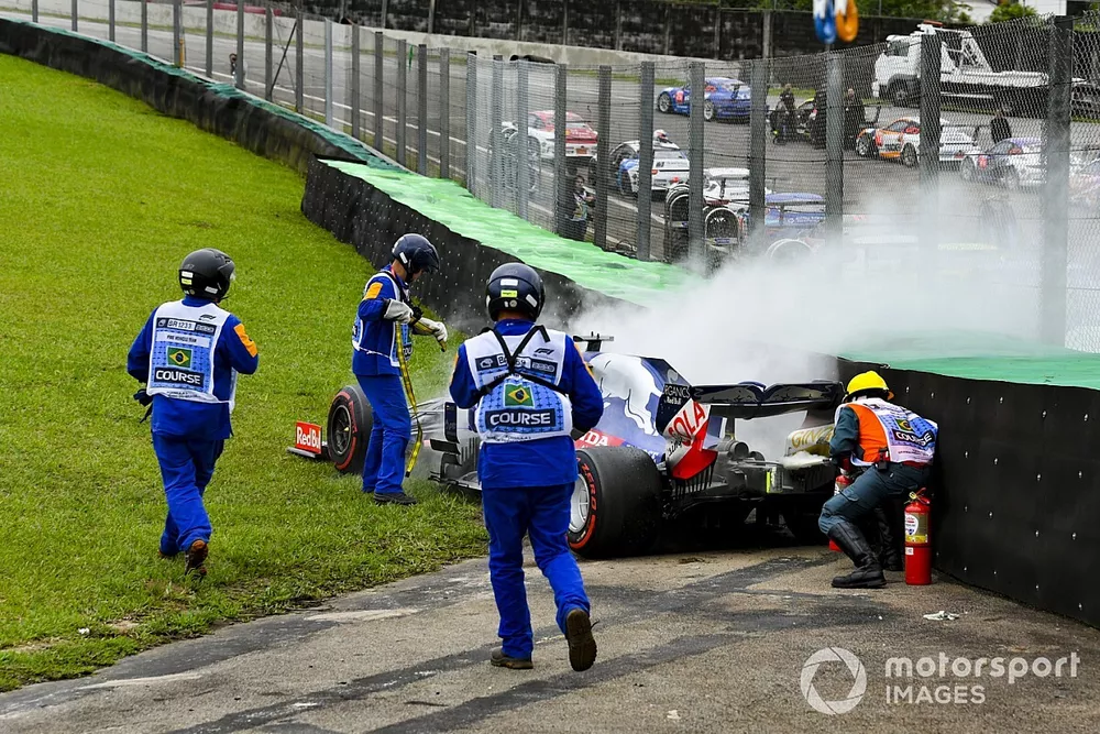 Marshals assist the smoking car of Daniil Kvyat, Toro Rosso STR14, with fire extinguishers