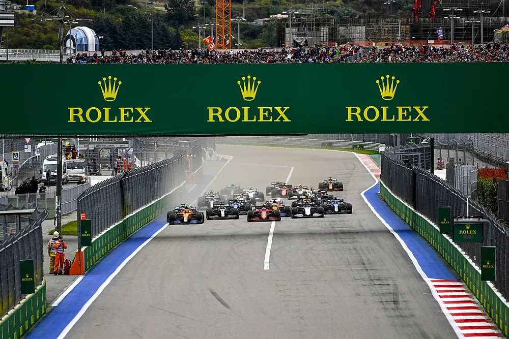 Lando Norris, McLaren MCL35M, Carlos Sainz Jr., Ferrari SF21, George Russell, Williams FW43B, Lance Stroll, Aston Martin AMR21, Fernando Alonso, Alpine A521, and the rest of the field at the start