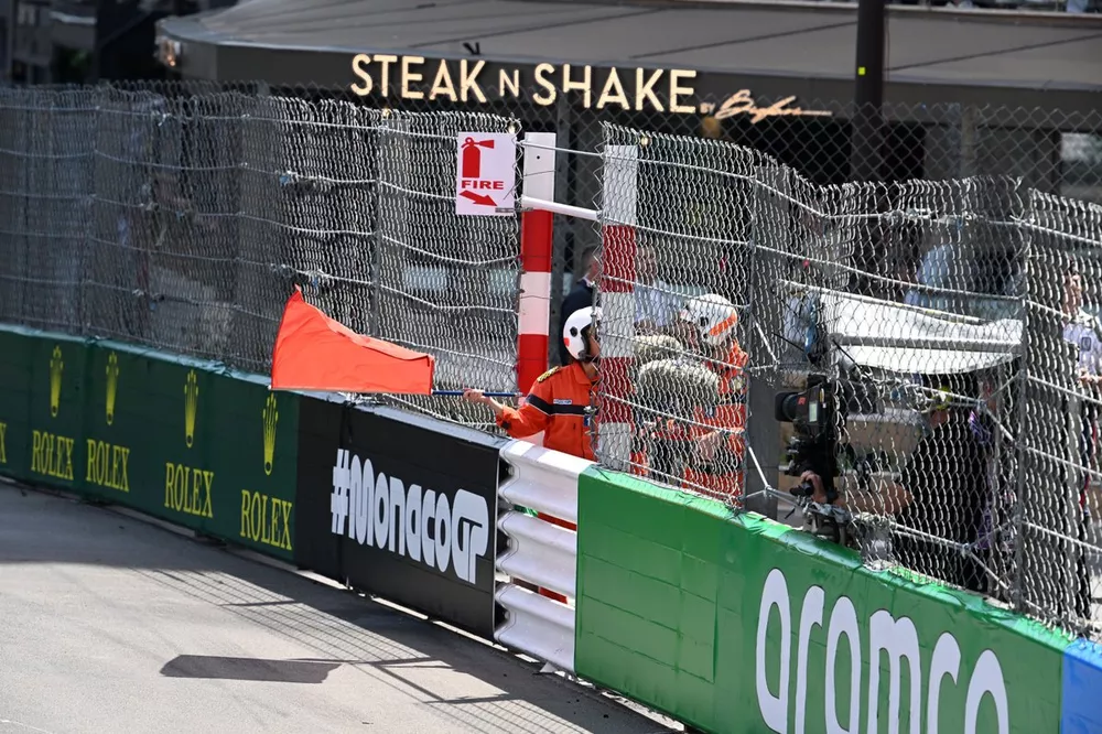 Um marechal agita a bandeira vermelha ap&oacute;s um acidente envolvendo Sergio Perez, da Red Bull Racing, Kevin Magnussen, da Haas F1 Team, e Nico Hulkenberg, da Haas F1 Team, na volta inicial