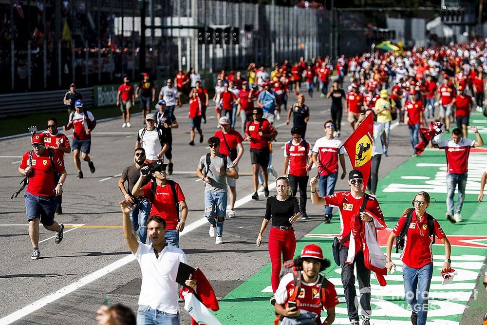 Tifosi storm the track with a Ferrari flag