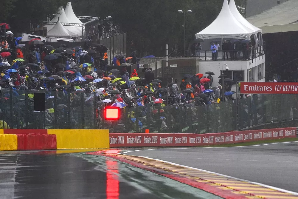 Puddles forming on the circuit and fans under umbrellas