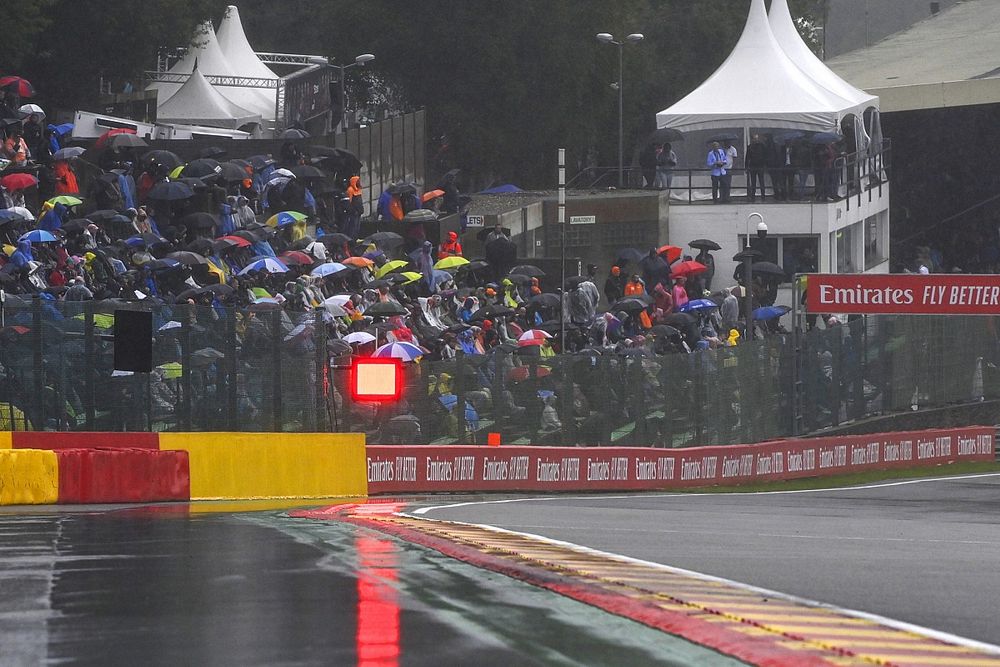 Puddles forming on the circuit and fans under umbrellas