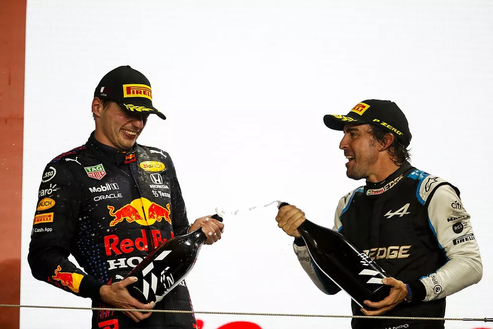 Max Verstappen, Red Bull Racing, 2de plaats, en Fernando Alonso, Alpine F1, 3de plaats, vieren op het podium met Rozenwater