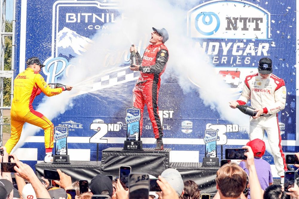 Will Power, Team Penske Chevrolet, Alex Palou, Chip Ganassi Racing Honda, ]osef Newgarden, Team Penske Chevrolet celebrate on the podium with champagne