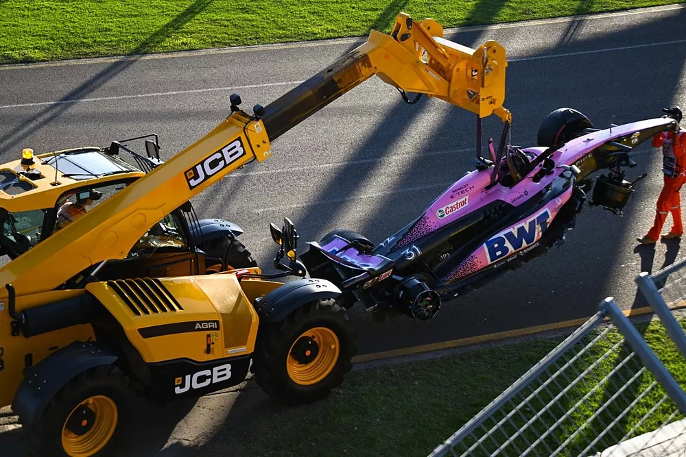 Los comisarios retiran el coche da&ntilde;ado de Esteban Ocon, Alpine A523, del circuito con una JCB