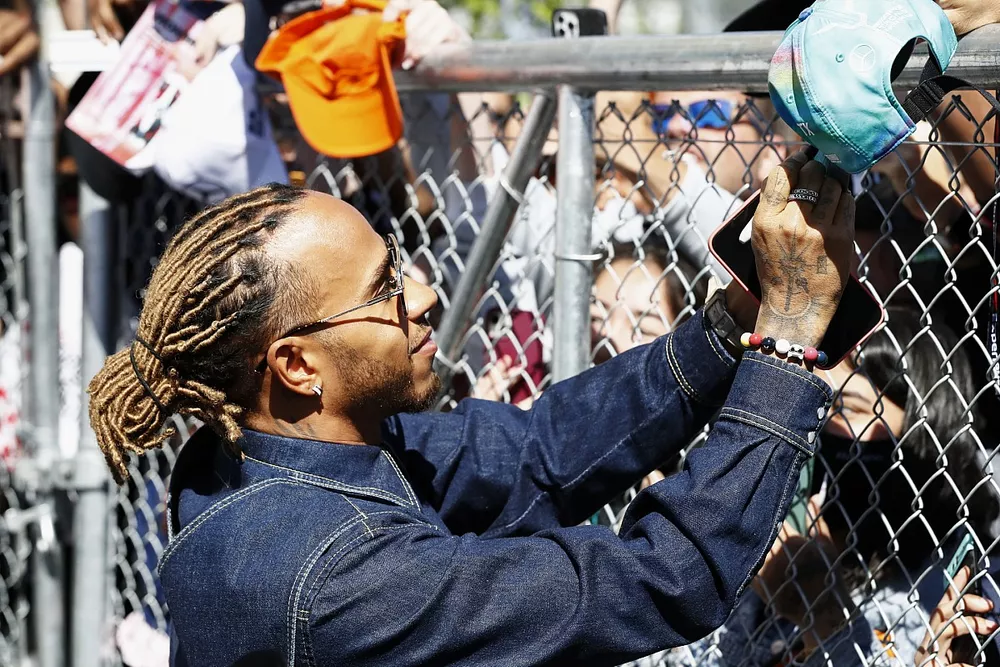 Lewis Hamilton, Mercedes-AMG, signs an autograph for a fan