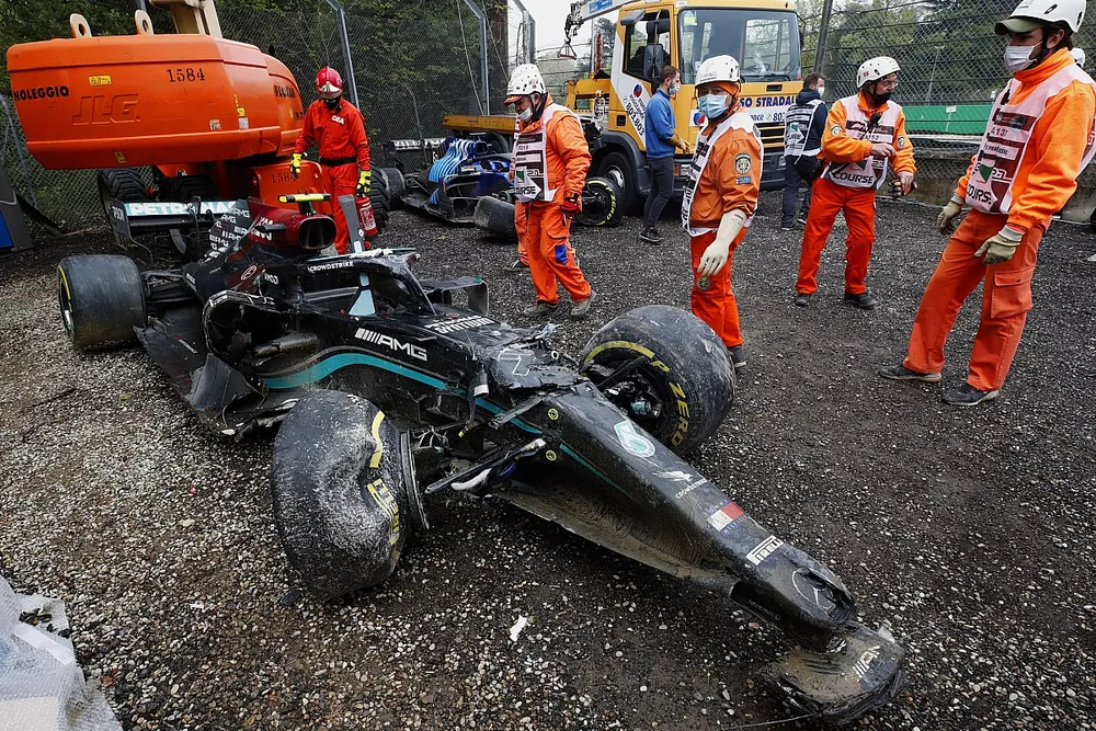 Marshals clear the damaged car of Valtteri Bottas, Mercedes W12, from the gravel trap