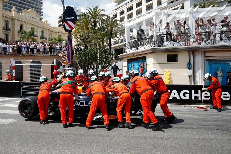 Marshals remove the damaged car of Sergio Perez, Red Bull Racing RB20, from the circuit after a crash on the opening lap