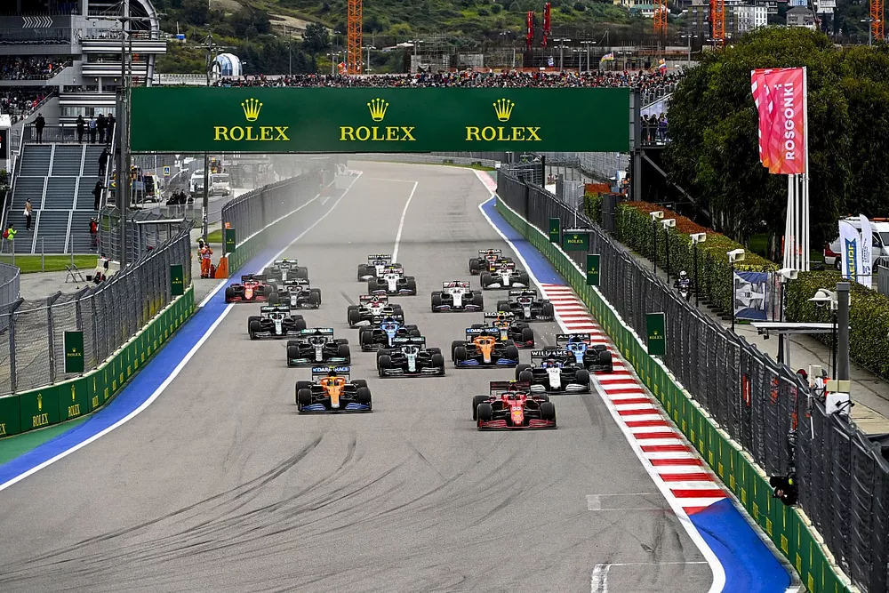 Carlos Sainz Jr., Ferrari SF21, Lando Norris, McLaren MCL35M, George Russell, Williams FW43B, Lance Stroll, Aston Martin AMR21, Fernando Alonso, Alpine A521, and the rest of the field at the start