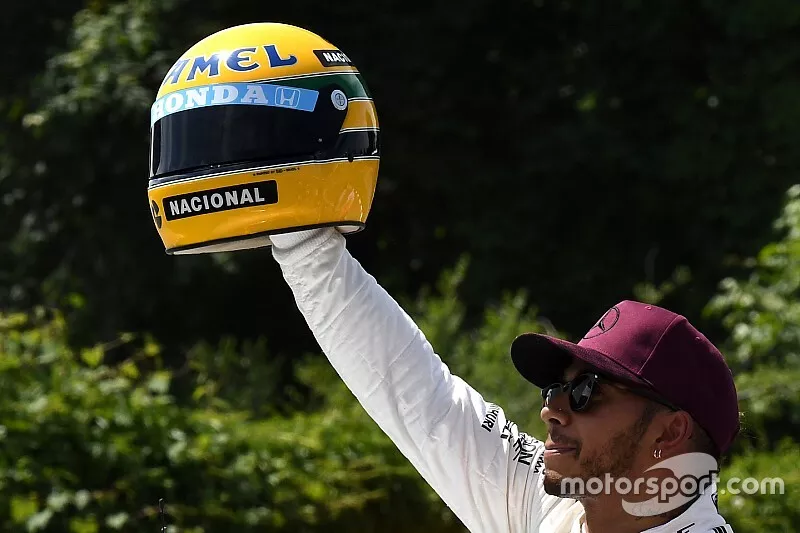 Pole sitter Lewis Hamilton, Mercedes AMG F1 celebrates in parc ferme, the helmet of Ayrton Senna