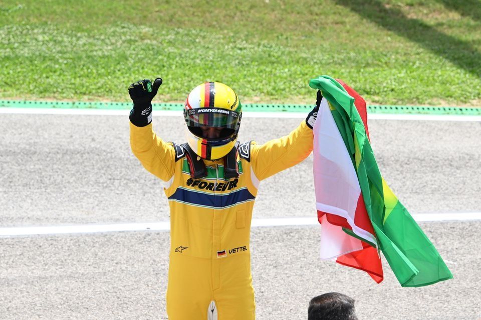 Sebastian Vettel waves the Austrian and Brazilian flags after driving Ayrton Senna's McLaren MP4/8