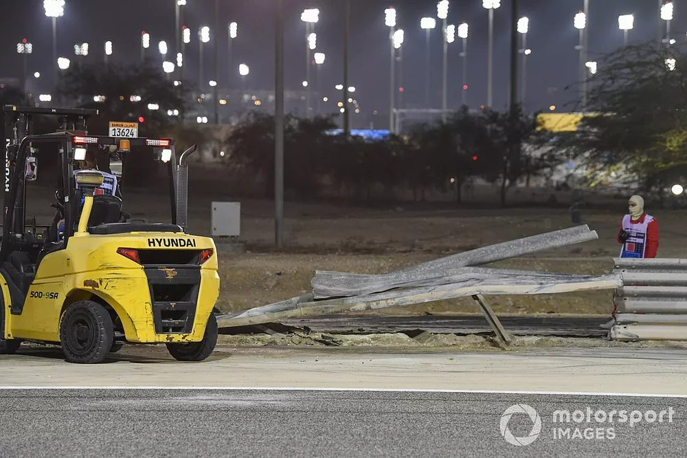 Marshals remove the wreckage after a huge crash for Romain Grosjean, Haas VF-20, on the opening lap