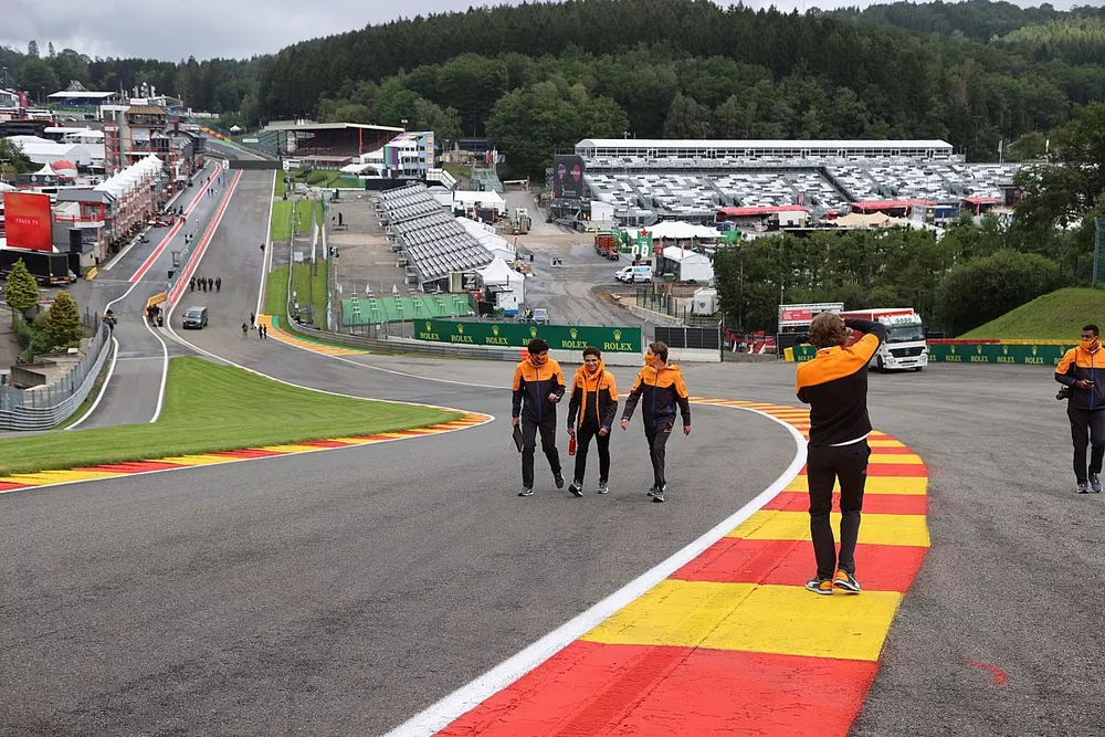 Lando Norris, McLaren, walks the track with members of his team