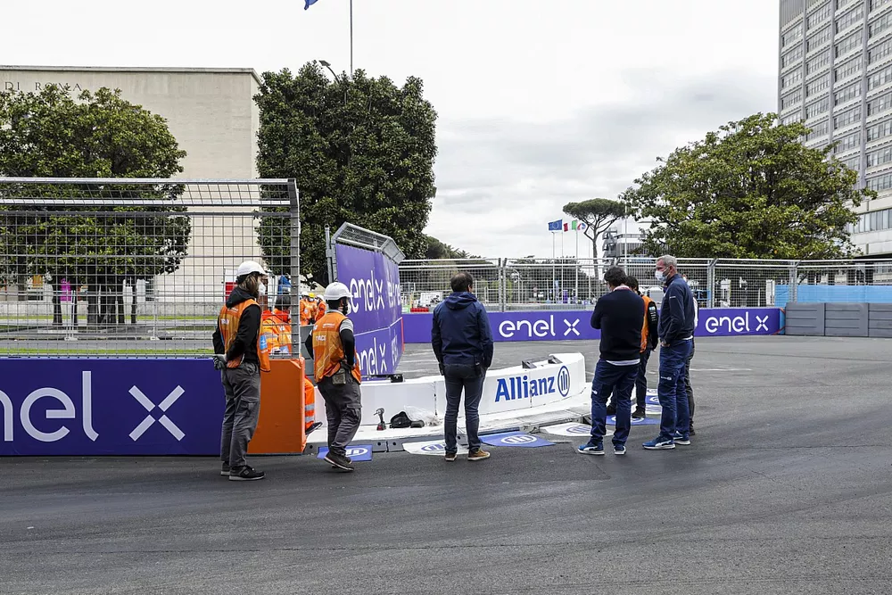Marshals and FIA members inspect the damaged kerb