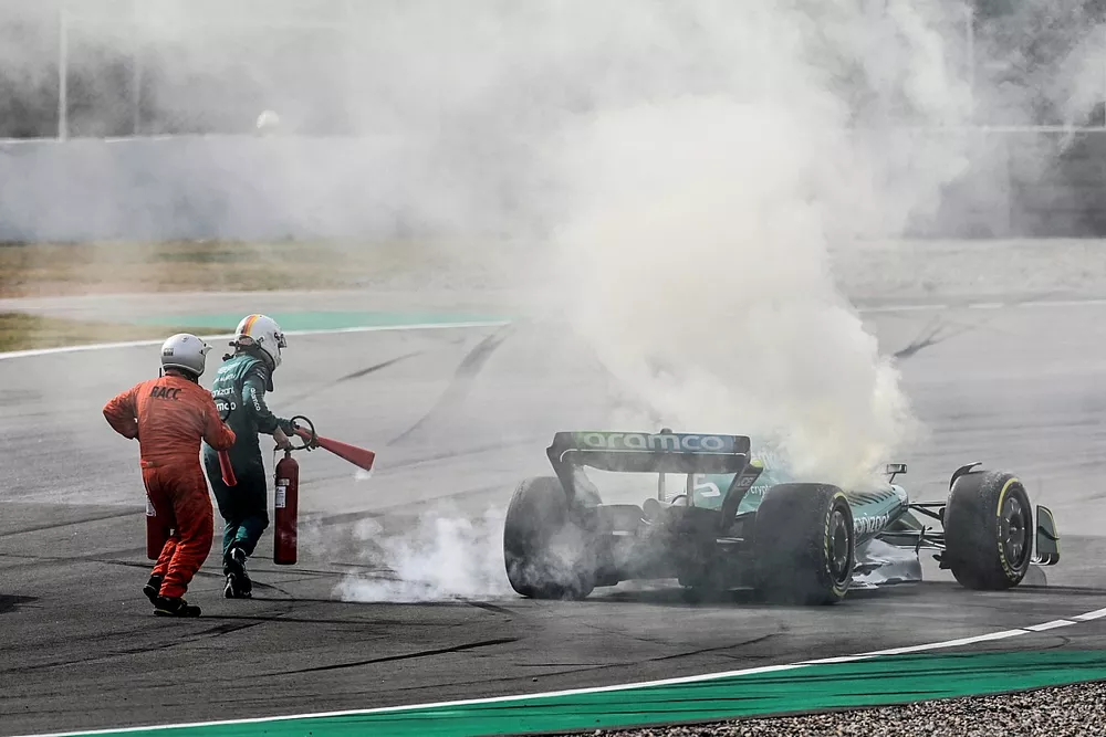 Marshals assist Sebastian Vettel, Aston Martin AMR22, after a technical failure results in smoke