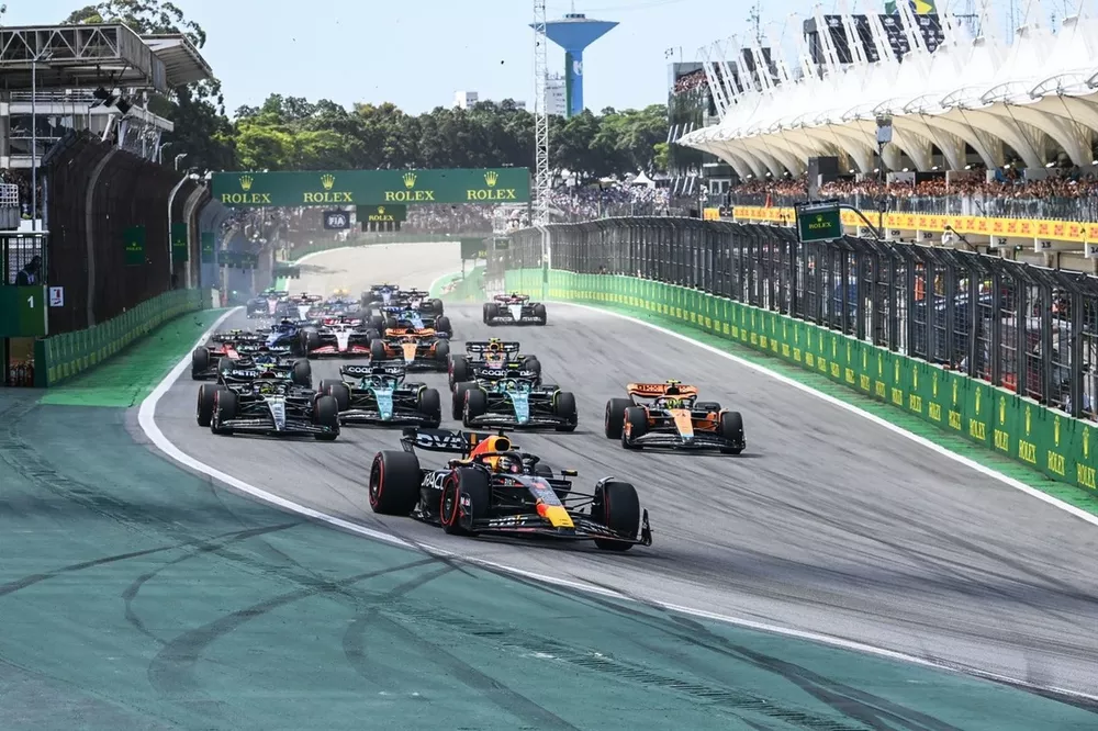 Max Verstappen, Red Bull Racing RB19, Lando Norris, McLaren MCL60, Lewis Hamilton, Mercedes F1 W14, Fernando Alonso, Aston Martin AMR23, Lance Stroll, Aston Martin AMR23, o resto do campo enquanto um acidente ocorre entre Kevin Magnussen, Haas VF-23, Alex Albon, Williams FW45