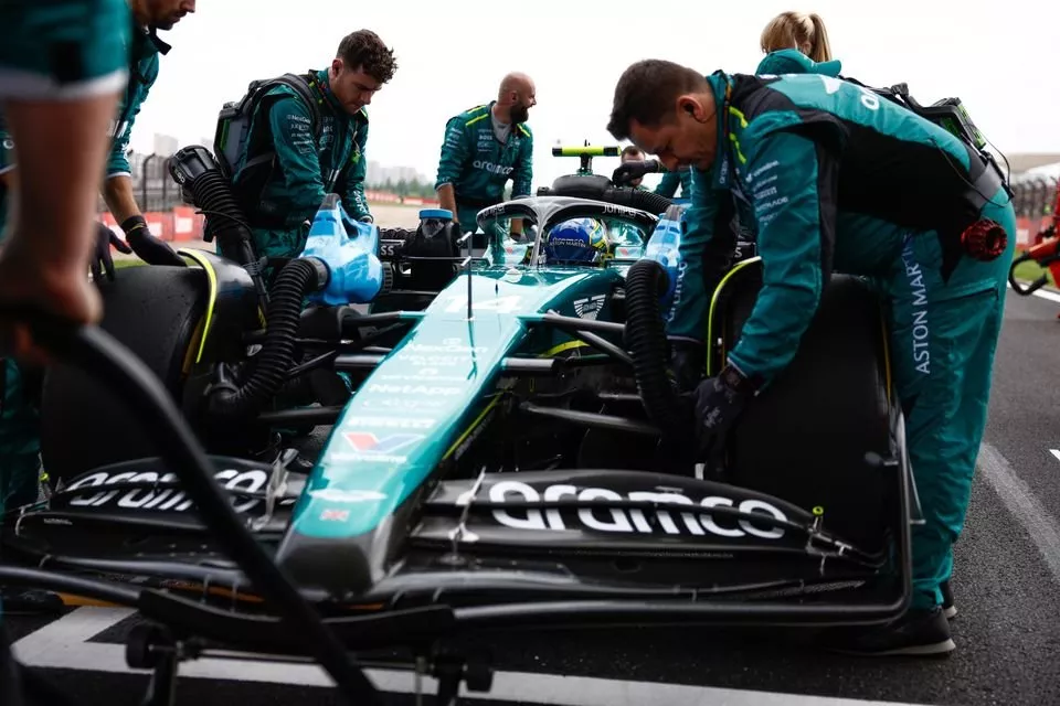 Mechanics of Aston Martin push the car of Fernando Alonso, Aston Martin AMR24 to its grid slot