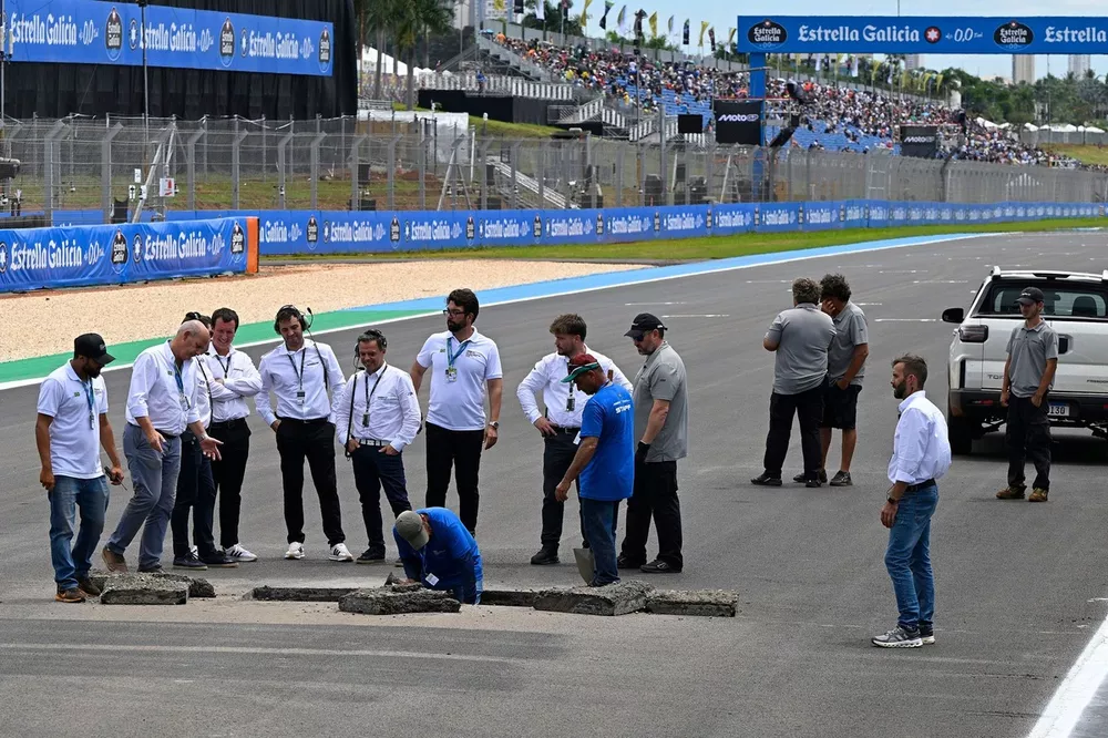 Officials repair a sinkhole on the start finish straight