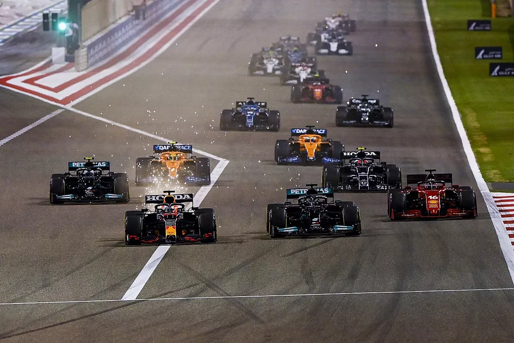 Sparks fly as Max Verstappen, Red Bull Racing RB16B, Lewis Hamilton, Mercedes W12, Charles Leclerc, Ferrari SF21, Valtteri Bottas, Mercedes W12, Lando Norris, McLaren MCL35M, and the rest of the field at the start