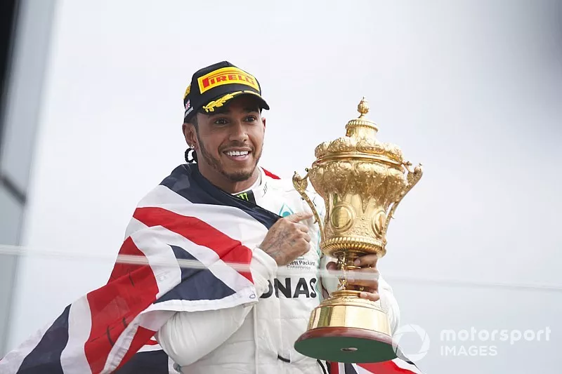 Race winner Lewis Hamilton, Mercedes AMG F1 celebrates on the podium with the trophy and with a flag