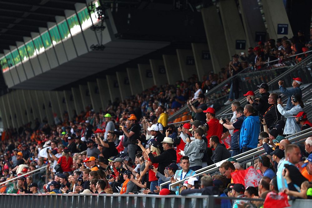 Los aficionados fotograf&iacute;an a los conductores en el autob&uacute;s del desfile