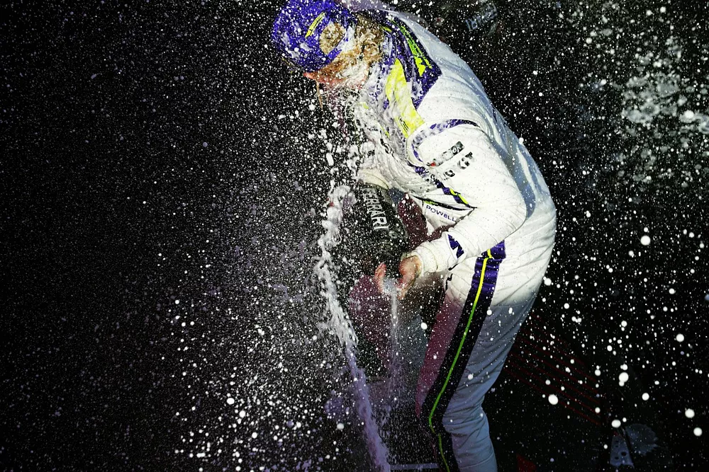 Alice Powell, 1st position, sprays the victory Champagne