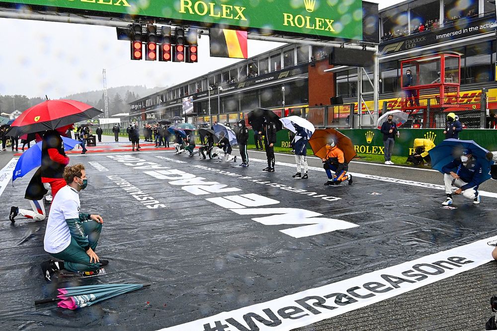 Los pilotos se ponen en pie y se arrodillan en la parrilla de salida en apoyo de la campa&ntilde;a Fin del Racismo